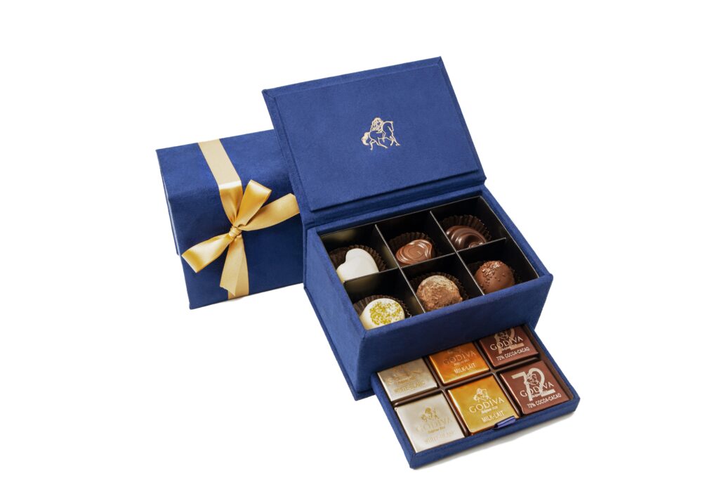 Open blue Godiva chocolate box with gold ribbon and assorted chocolates – e-commerce product photo by Food On Focus Media