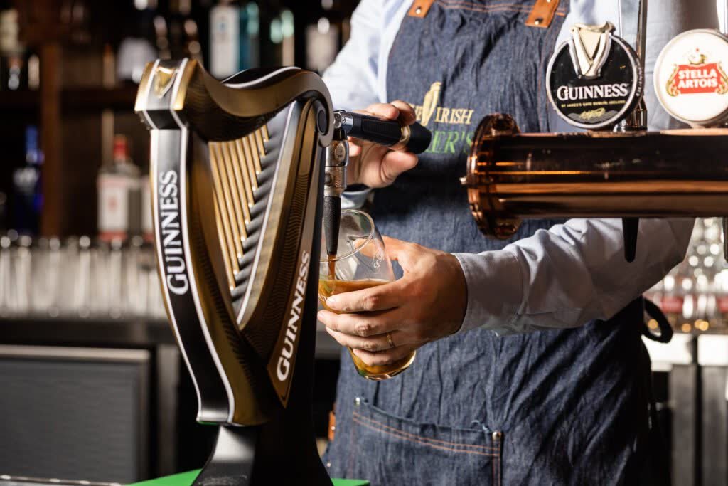 Bartender pouring a drink at the taps, filmed and photographed at Irish Vickers in Dubai