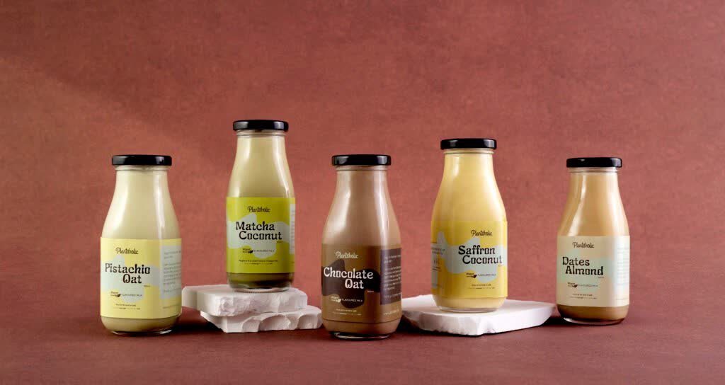 Five Plantoholic flavoured milk bottles, from pistachio oat to dates almond, on terracotta