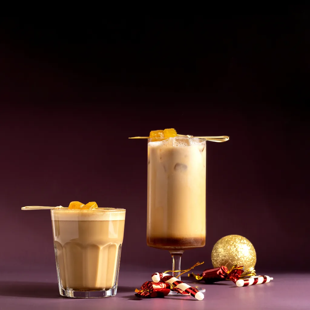 Two iced oat lattes styled with festive decorations