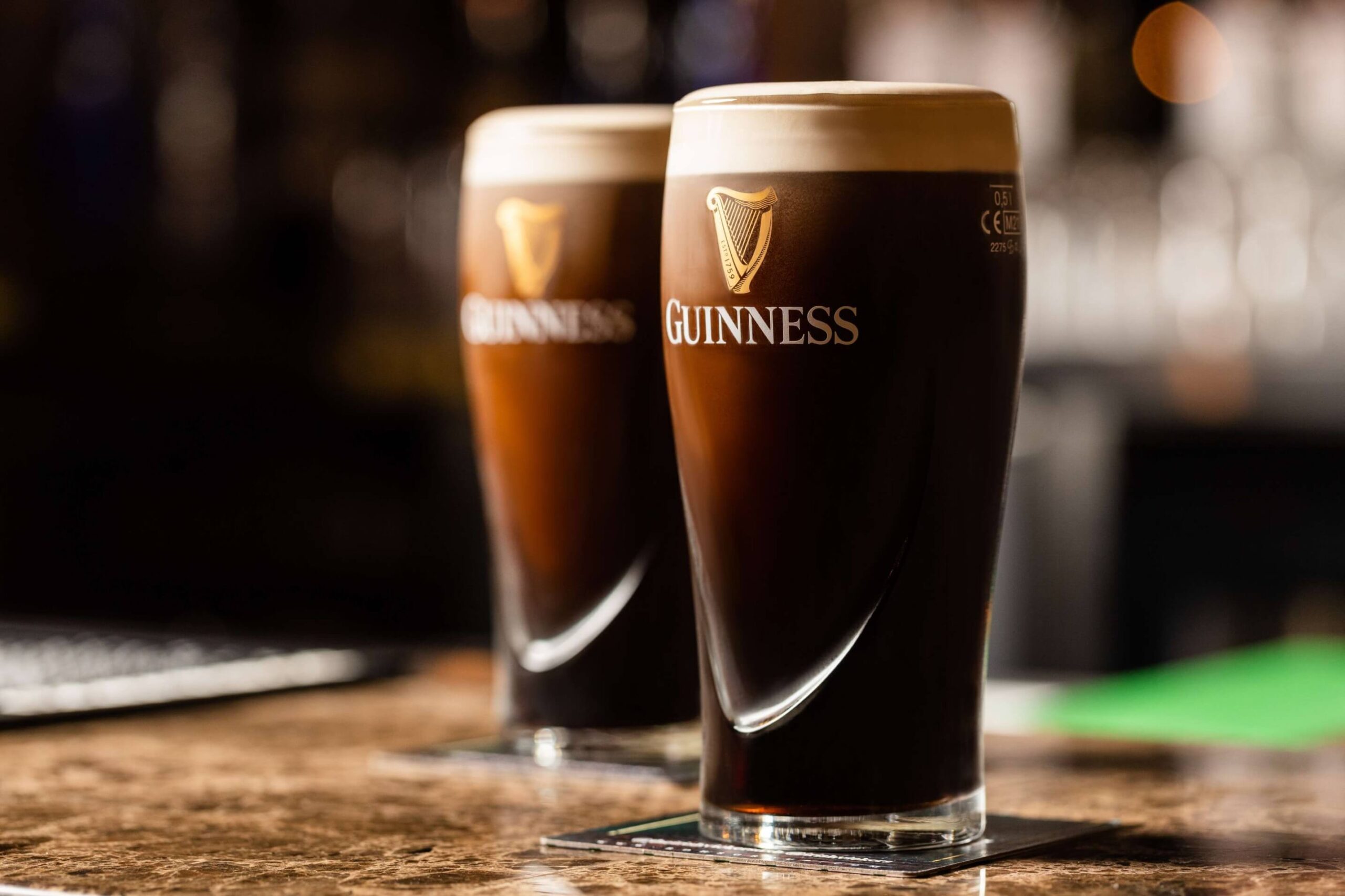 Two glasses of Guinness beer with bold white text overlay stating "One-stop solution for all your F&B creative needs.