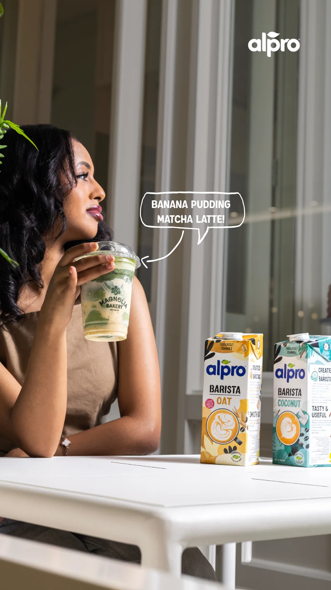 Campaign still of a woman with a matcha latte and Alpro cartons