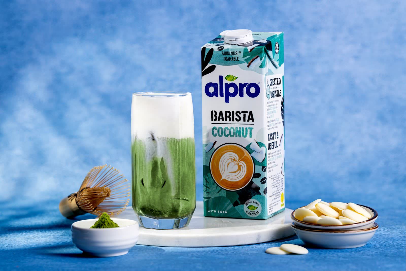 Alpro Barista Coconut carton photographed beside the prepared drink